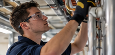 Installateur werkt aan leidingen onder het plafond